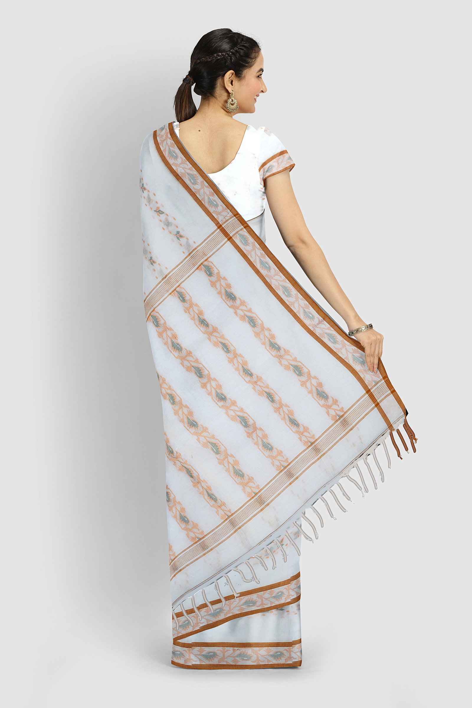 White Tangail cotton saree with handwoven floral work, draped to show the soft Bengal handloom fabric